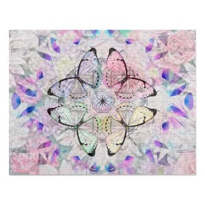 Può includere: Un design di mandala colorato con cinque farfalle in uno schema circolare. Le farfalle sono in tonalità di rosa, blu, verde e bianco. Lo sfondo è un rosa pastello morbido e bianco.