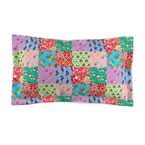 Pode incluir: Uma fronha de patchwork com uma variedade de quadrados coloridos que apresentam padrões florais e geométricos. A fronha é feita de tecido macio e confortável e é perfeita para adicionar um toque de capricho a qualquer quarto.