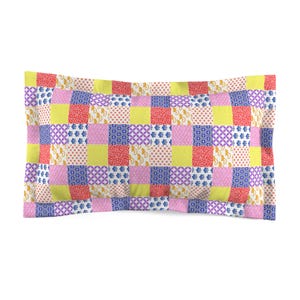May include: A yellow, pink, blue and red patchwork pillow with a geometric pattern.