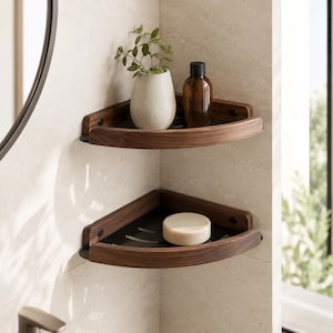 Peut inclure: Deux étagères d'angle superposées en bois foncé avec des bases en métal noir. L'étagère supérieure contient une petite plante en pot et une bouteille en verre brun. L'étagère inférieure contient un savon rond blanc. Fixées dans un angle carrelé.