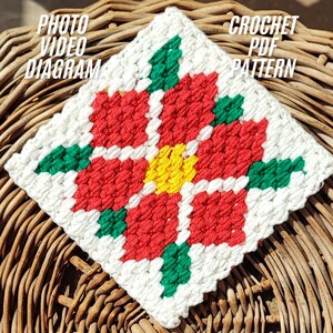 Könnte beinhalten: Ein quadratischer, gehäkelter Artikel mit einem Blumenmuster in Rot, Gelb, Grün und Weiß. Der Text "PHOTO VIDEO DIAGRAM" und "CROCHET PDF PATTERN" sind sichtbar. Es wird auf einer gewebten Oberfläche präsentiert.