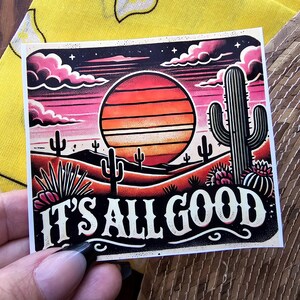 May include: A retro-style illustration of a desert sunset with a cactus and the text "It's All Good". The illustration is in shades of pink, orange, and yellow.