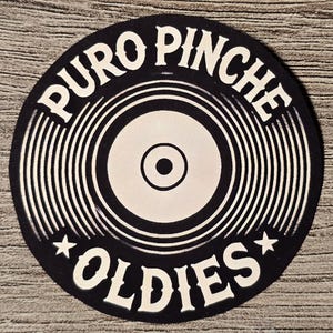Op de afbeelding: Zwart-wit vinyl platen ontwerp met de tekst "PURO PINCHE OLDIES" in een cirkel rond een gestileerde plaat.
