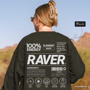 Könnte beinhalten: Schwarzes Langarmshirt mit dem Wort "RAVER" in großen weißen Buchstaben. Das Shirt hat den Text "100% ENERGY ELEMENT BASS" und eine Liste von Zutaten und Symbolen. Das Shirt ist Teil der Rave-Kultur.