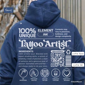 Op de afbeelding: Marineblauwe hoodie met witte tekst en afbeeldingen. De achterkant van de hoodie heeft de woorden "Tattoo Artist" en andere tekst, waaronder "100% Unique" en "Element Ink". De hoodie heeft ook een QR-code en pictogrammen.
