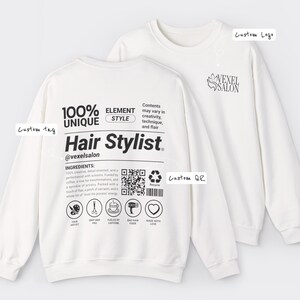 Könnte beinhalten: Zwei weiße Sweatshirts. Eines zeigt den Text "Hair Stylist", einen QR-Code und Symbole. Das andere hat ein "Vexel Salon"-Logo. Das erste Sweatshirt hat auch den Text "100% Unique Element Style" und "Ingredients".