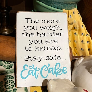 The more you weigh the harder you are to kidnap, stay safe... Eat Cake, Funny kitchen sign, kitchen wall decor, bakery sign