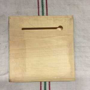 Peut inclure: Une plaque en bois clair et lisse avec une fente rectangulaire et un trou rond dans le coin sup&eacute;rieur droit.