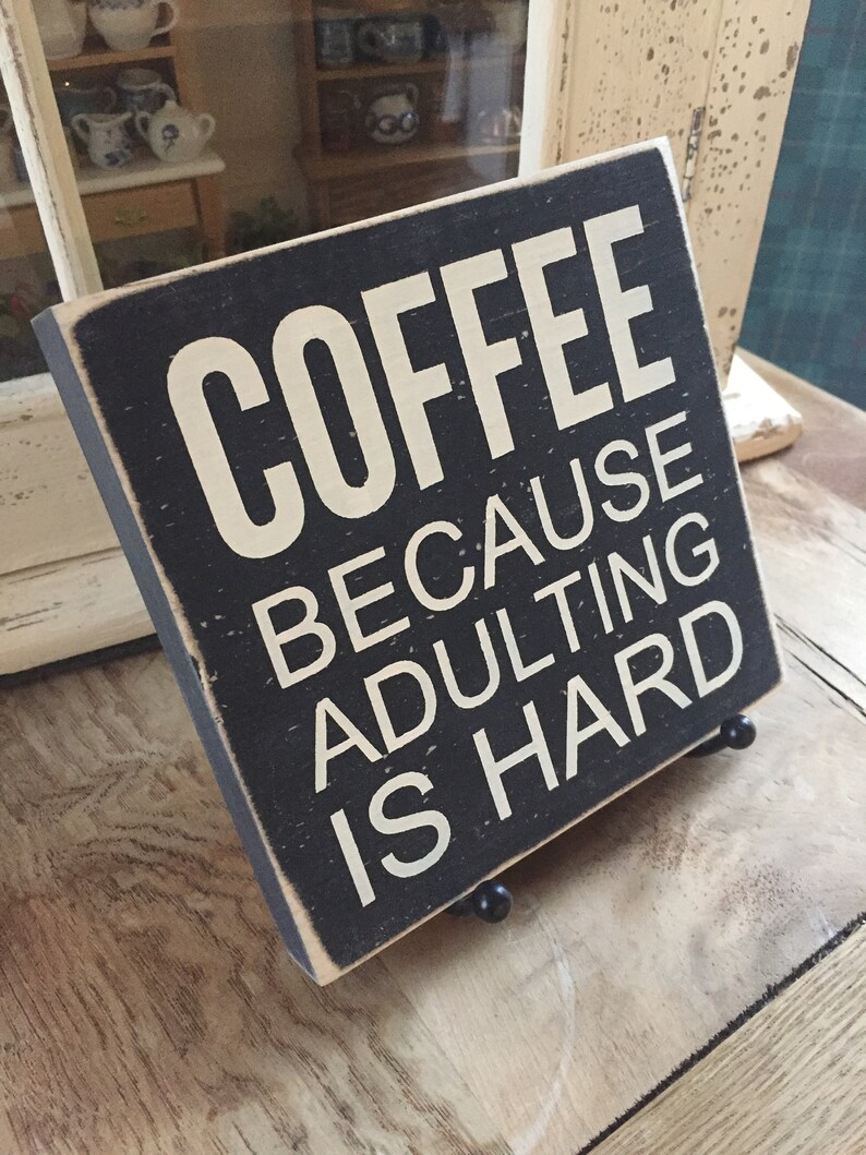 Peut inclure: Une pancarte en bois noir avec du texte blanc qui dit "COFFEE BECAUSE ADULTING IS HARD".