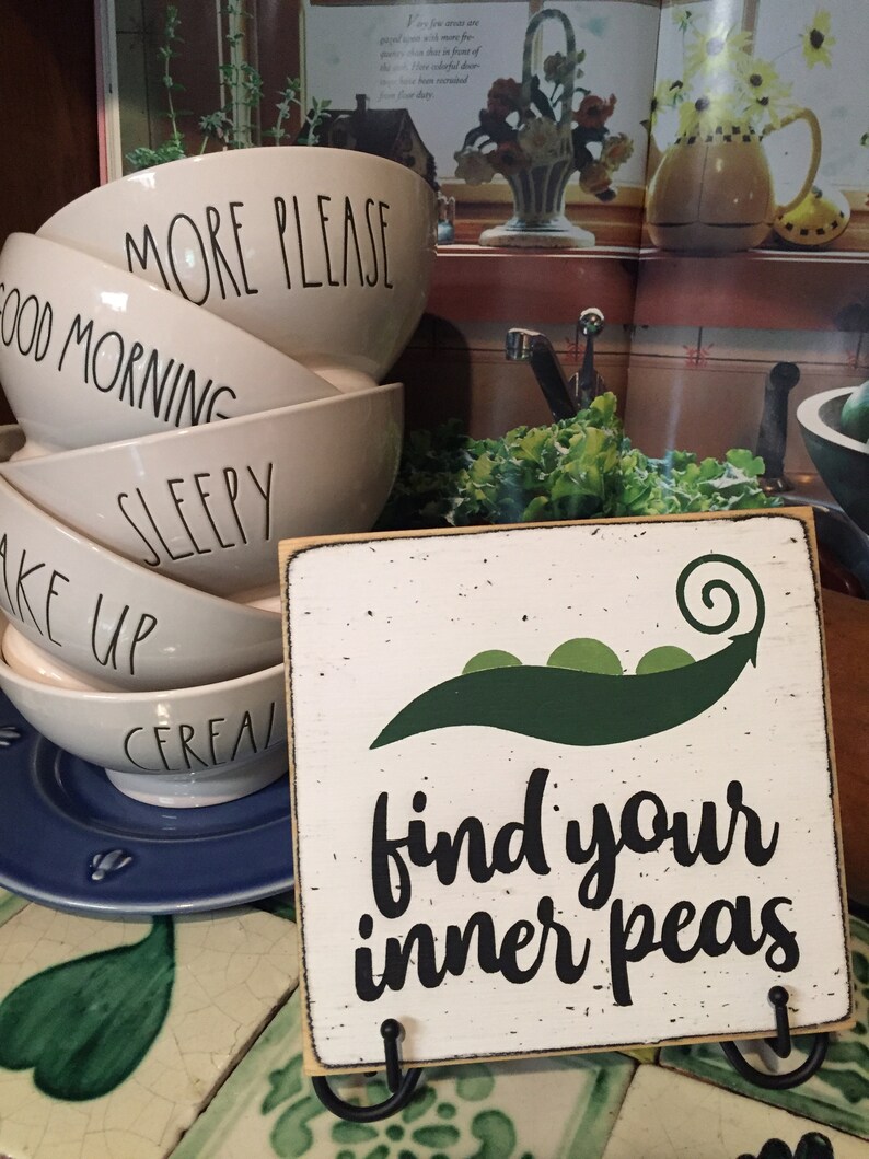 May include: White wooden sign with a green pea pod and the text "find your inner peas".