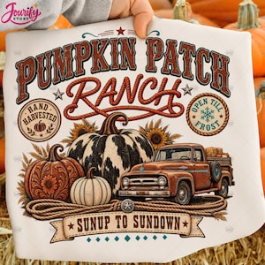 May include: A white t-shirt featuring a graphic with the text PUMPKIN PATCH RANCH, SUNUP TO SUNDOWN, HAND HARVESTED, and OPEN TILL FROST. The design includes a rusty orange pickup truck, three pumpkins, sunflowers, wheat stalks, and rope accents.