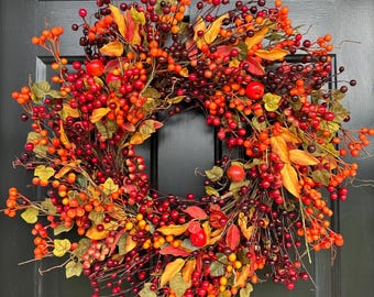 Ghirlanda autunnale con foglie e bacche: decorazione autunnale per la porta d'ingresso.