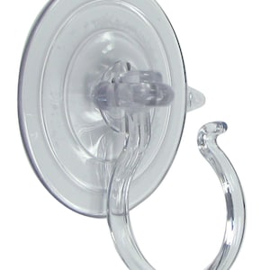 May include: A clear plastic suction cup hook with a rounded hook. The hook is designed to be attached to smooth surfaces like glass or tile.