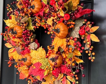 Corona de otoño con calabazas, bayas y hojas otoñales, decoración artesanal para la puerta principal con follaje otoñal.