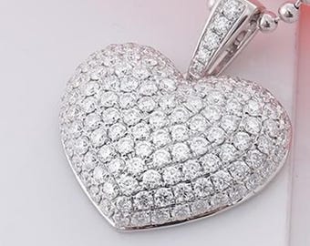 May include: A heart-shaped pendant necklace with a silver chain. The pendant is encrusted with numerous small, sparkling diamonds. The pendant's bail is also adorned with diamonds, adding to its brilliance. The necklace is a piece of jewelry.