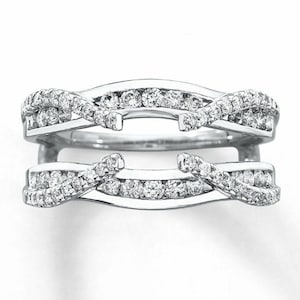May include: A silver ring enhancer with a delicate, intertwined design featuring small diamonds.