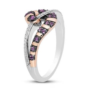 May include: A silver and rose gold ring with a twisted design. The ring is set with small purple and white gemstones.