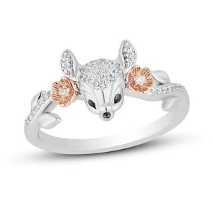 May include: A silver ring with a diamond-encrusted deer head and two rose gold flowers with diamond centers.