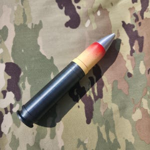 May include: A black and yellow military-style projectile with a red tip and a silver nose cone.