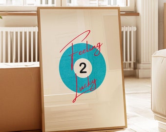 May include: A framed print with a blue circle and the text "Feeling 2 Lucky" in red cursive. The circle has a white number "2" inside.