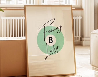 May include: A framed print with a green and white illustration of a pool ball with the number 8 on it. The text "Feeling Lucky" is written in black cursive above the ball.