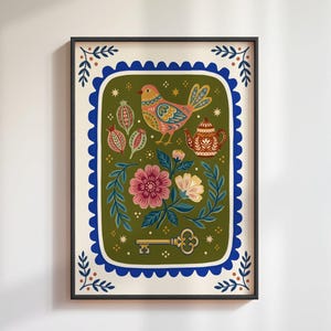 Könnte beinhalten: Ein gerahmter, rechteckiger Kunstdruck mit einem zentralen olivgrünen Feld und einem gewellten blauen Rand. Die Illustration zeigt einen bunten Vogel, eine Teekanne, Blumenarrangements, Samenkapseln und einen goldenen Schlüssel mit kleinen Sternen.