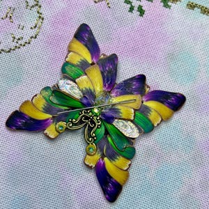 May include: A white ceramic mug with a black handle and the text "But First, Coffee" in a bold, black font. The mug is set against a neutral background, highlighting its simple design.