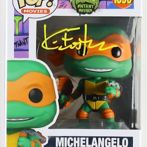 May include: A Funko Pop! Movies figure of Michelangelo from Teenage Mutant Ninja Turtles: Mutant Mayhem. The figure is green, orange, and yellow, with a signature on the box. The box also features the Nickelodeon and Funko Pop! logos.