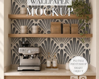 May include: A digital mockup template featuring a kitchen scene with light wood cabinets, two floating shelves, and a gray and white fan-patterned wallpaper. The scene includes a silver espresso machine, ceramic mugs, coffee bags, and a trailing plant.