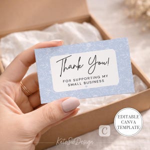 May include: A light blue business card with the words "Thank You!" in elegant script. The card also reads "For Supporting My Small Business." The card has a floral pattern and is held in a brown box.