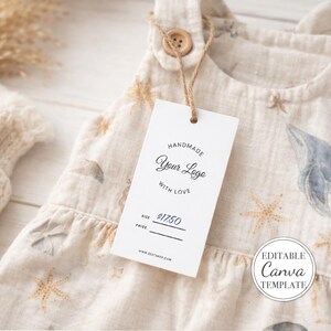 May include: A beige sleeveless romper featuring a pattern of blue whales and tan starfish, with a wooden button at the shoulder. A white rectangular tag hangs from the button, printed with "HANDMADE Your Logo WITH LOVE", "SIZE", "PRICE $17.50", and "WWW.BESTSHOP.COM".