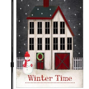 May include: A winter-themed garden flag featuring a white house with red trim and a snowman in front. The house has a red door and a wreath. The flag has a black background with white snowflakes and the text "Winter Time".