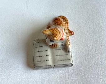 Cat figure, orange, brown, Lying, reading book, kitten, Ceramic Cat Figurine, ceramic figure, animal figure, cat figurine, animal figurine