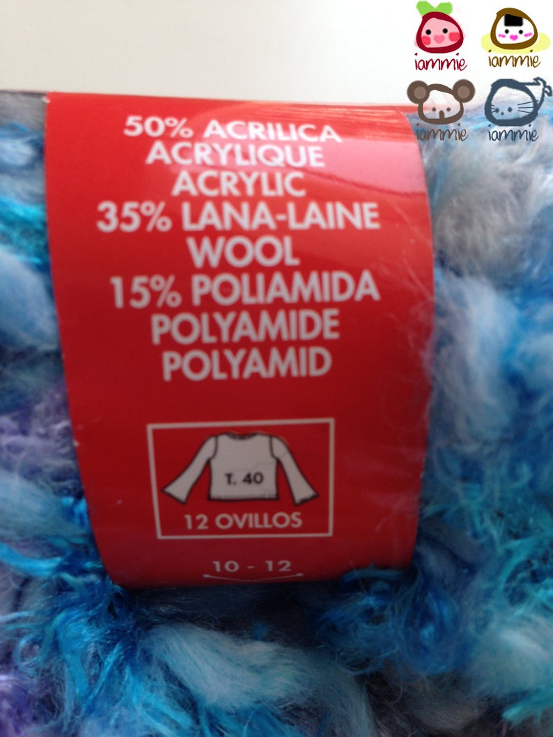 May include: A red label with white text detailing the yarn composition: 50% Acrylic, 35% Wool, 15% Polyamide. The label also includes a white graphic of a sweater with the text "T. 40" and "12 Ovillos" and "10-12". The yarn is a blue and white fuzzy texture.