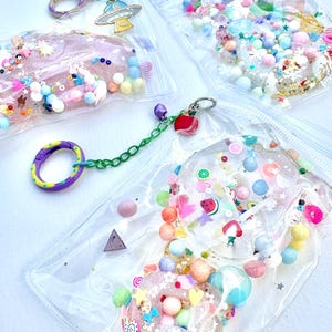 SOFT Squishy Toys, Spaß glitzernd glamourös, langsam aufsteigend, klar, transparent, glitzert, bunt, regenbogen, party, rosa, Schlüsselanhänger, Tamagotchi