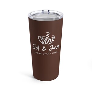 Peut inclure: Un gobelet de voyage marron avec un couvercle argenté. Le gobelet porte le texte blanc "Jot & Java" avec un motif de tasse à café et le slogan "IDEAS START HERE". Le gobelet est conçu pour garder les boissons chaudes ou froides.