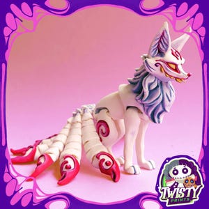 May include: A white and red fox figurine with a detailed design. The fox has multiple tails with red tips and swirls. The fox has a white body with blue and white fur around its neck and head. The figurine has a pink background and a purple border.