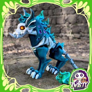 Puede incluir: Figura de criatura esquelética de color verde azulado y blanco, con cabeza de calavera y ojos naranja brillante. La figura tiene un diseño detallado con una estructura ósea estilizada y está en posición de caminar. La base de la figura tiene el texto "Twisty Prints".