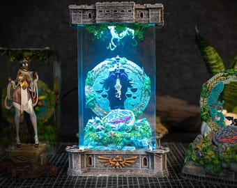 May include: A glass display case with a blue light inside, featuring a detailed miniature of a dragon and a circular design with a green and gold color scheme. The case is on a stone base with a decorative design.