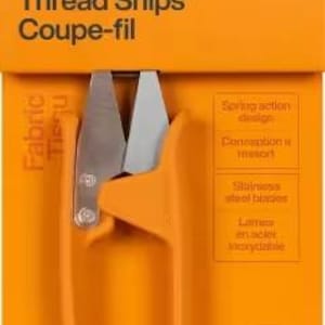 Puede incluir: Tijeras para hilo Fiskars naranjas en su embalaje. El paquete presenta el logotipo de Fiskars, el nombre del producto y las palabras « Coupe-fil ». El paquete también incluye el texto « Fabric », « Spring action design », « Stainless steel blades » y « World's #1 Scissors Brand ».