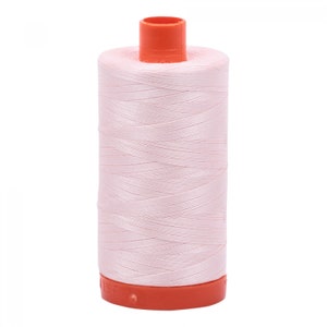 May include: A spool of pale pink thread with an orange plastic bobbin.