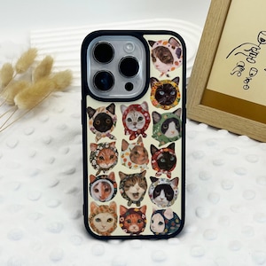 Könnte beinhalten: Eine Handyhülle mit einem sich wiederholenden Muster von Katzenköpfen, die verschiedene Hüte und Mützen tragen. Die Katzen haben verschiedene Farben, darunter Schwarz, Orange und Weiß, auf einem cremefarbenen Hintergrund. Die Hülle hat einen schwarzen Rand.