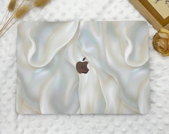 May include: A white laptop skin with a pearlescent, iridescent, and textured design. The skin features a subtle, swirling pattern that resembles flowing fabric. The Apple logo is visible in the center of the skin.
