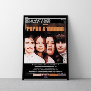 Puede incluir: Un póster enmarcado con la banda The Mamas & the Papas. El póster tiene un borde negro y muestra las caras de los miembros de la banda. El nombre de la banda está en texto naranja, y la lista de canciones del álbum está en la parte inferior.