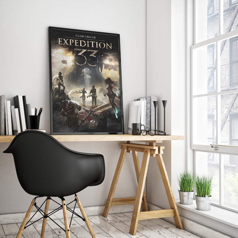 May include: A framed poster with the text "CLAIR OBSCUR EXPEDITION 33" is displayed on a wooden desk. The artwork features a fantasy scene with figures and a dark, dramatic sky. A black chair and a window with a view of a building are also visible.