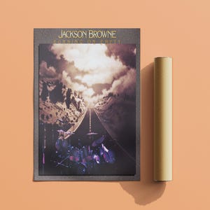 Op de afbeelding: Een vintage albumhoes voor Jackson Brownes album "Running on Empty". De hoes toont een zwart-witfoto van een snelweg die in de verte verdwijnt met een band die op de voorgrond drums speelt.