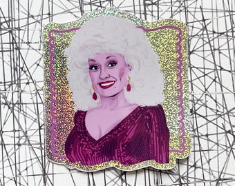 May include: A glittery sticker featuring a portrait of a woman with blonde hair, wearing a pink dress and earrings. The sticker has a gold background with a pink border.
