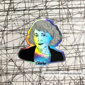 Pode incluir: Um adesivo holográfico com um desenho em preto e branco de uma mulher com cabelo curto. O adesivo tem um acabamento arco-íris iridescente e o nome "Claire" está escrito abaixo da imagem. O texto "alex kittle 2019 panandscan.etsy.com" está impresso abaixo do nome.