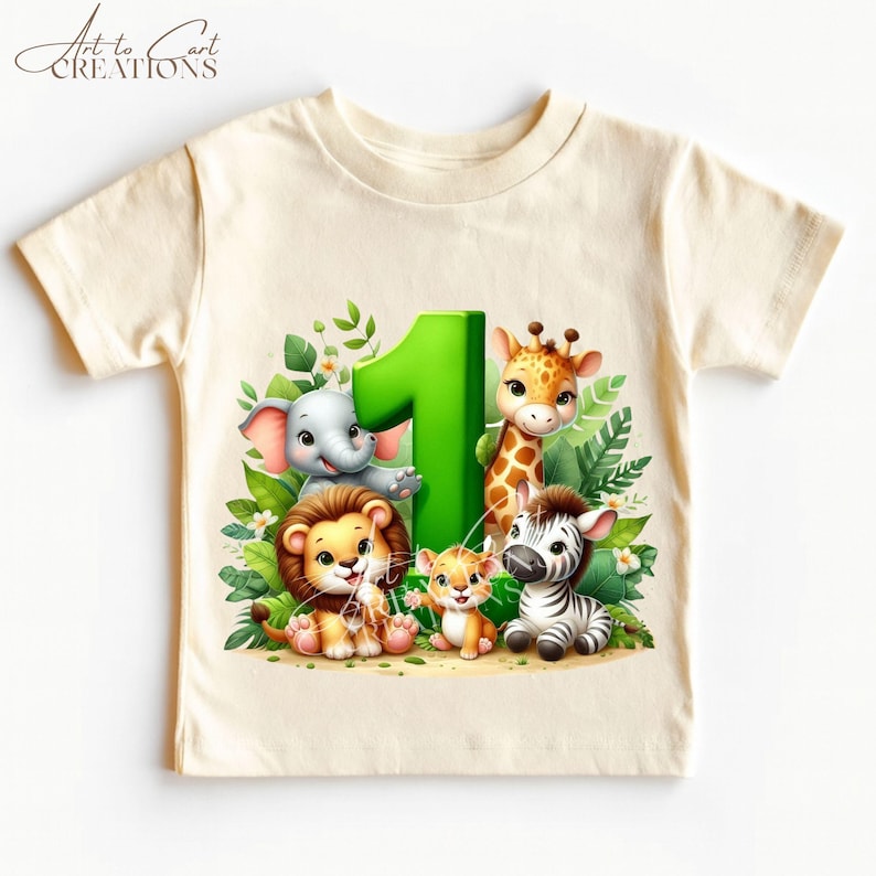 以下が含まれることがあります： ジャングルをテーマにした、クリーム色の幼児用Tシャツ。デザインには、緑色の大きな数字1と、象、ライオン、キリン、シマウマ、2匹の子どもたちの漫画の動物が、緑の葉の背景に囲まれています。