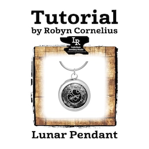 May include: A silver pendant with a black and silver design, hanging from a silver chain. The pendant is in a wooden frame with the text "Lunar Pendant" below it. The text "Tutorial by Robyn Cornelius" is above the frame.